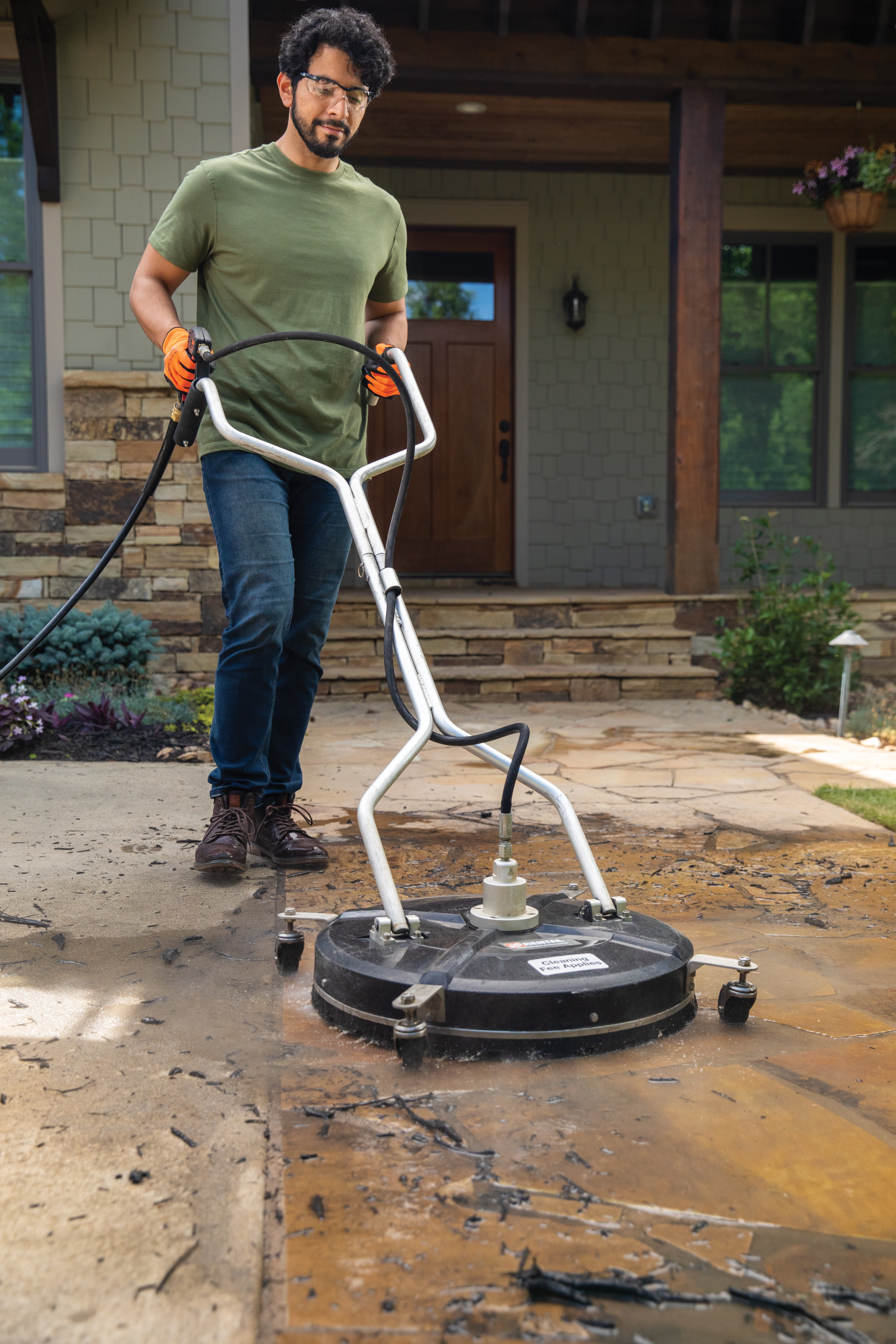 Professional cleaning team member with power washing equipment