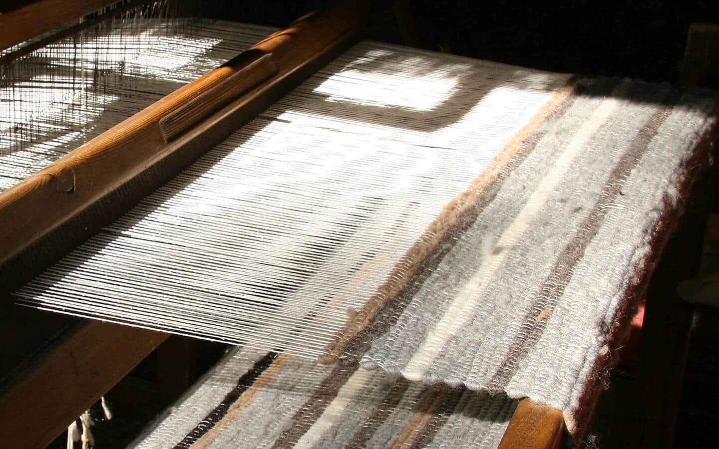 A rug being woven on an traditional loom.