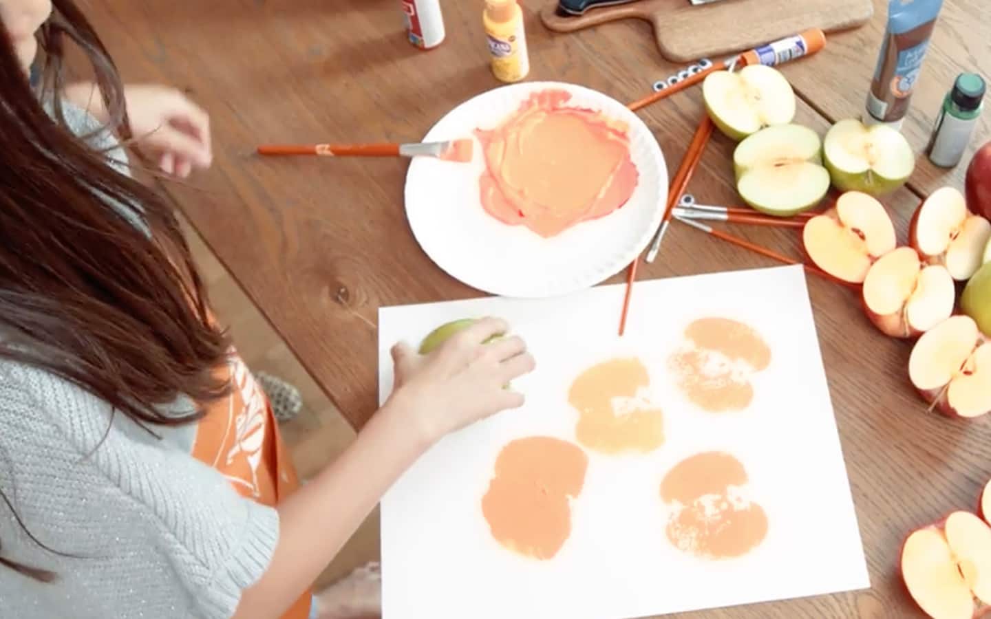 An apple stamp is pressed on the paper to make the pumpkin shape. An apple stamp is pressed on the paper to make the pumpkin shape.