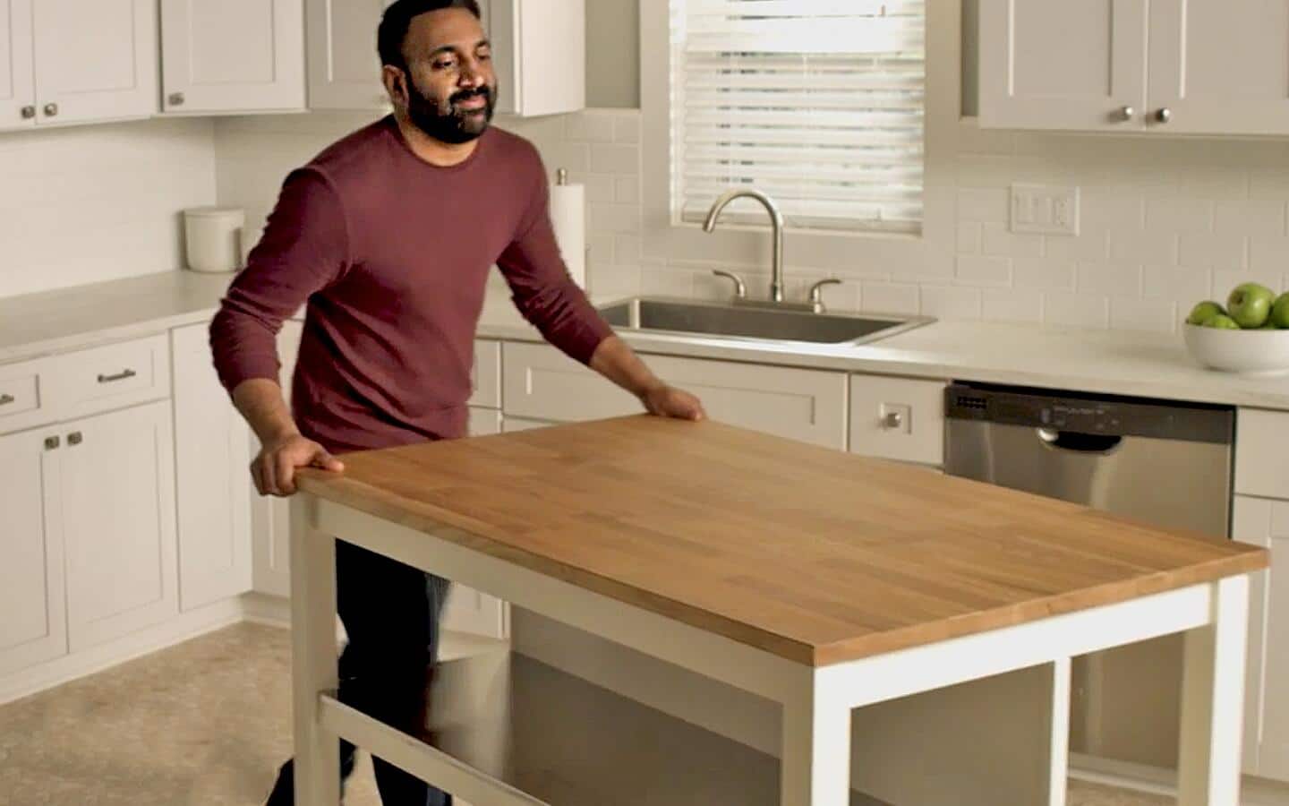 Someone moving a kitchen island before removing vinyl flooring. Someone moving a kitchen island before removing vinyl flooring.