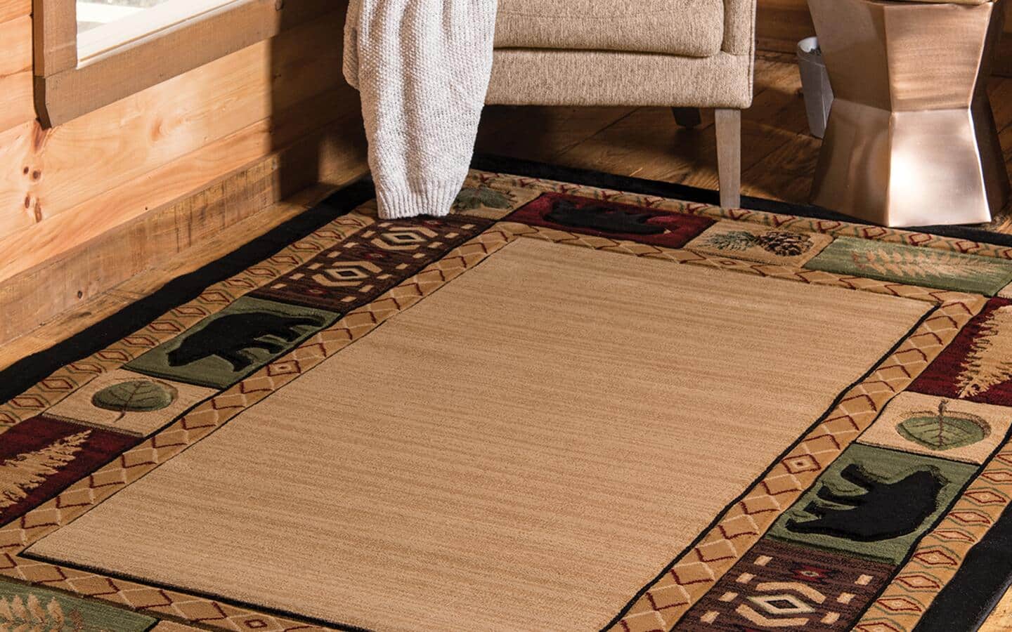 A lodge rug features bears, moose and evergreen trees.