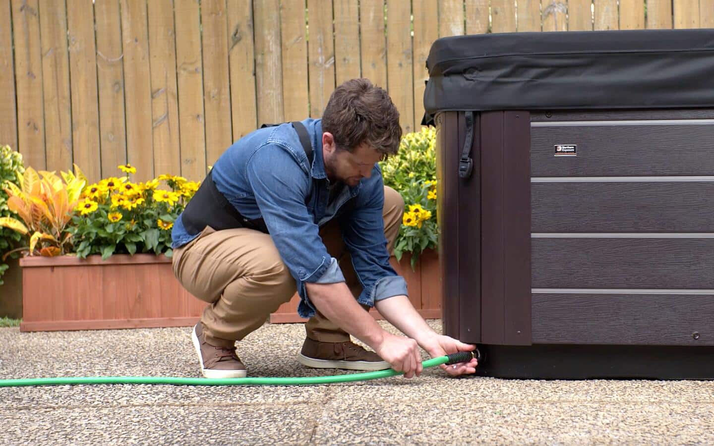 A hose being disconnected from an outdoor hot tub.