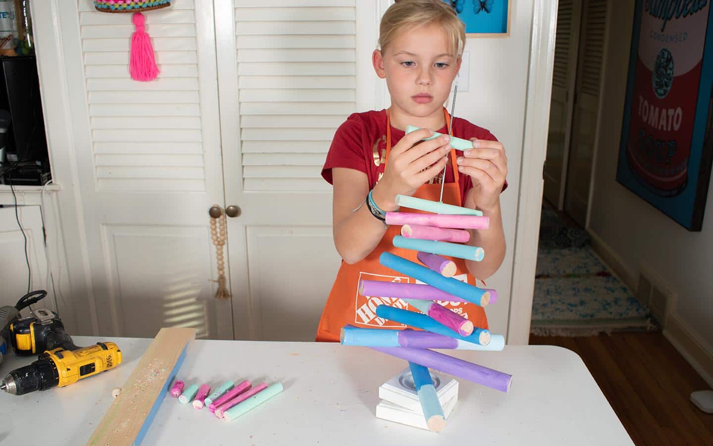 Girl stacking painted dowels onto post. Girl stacking painted dowels onto post.
