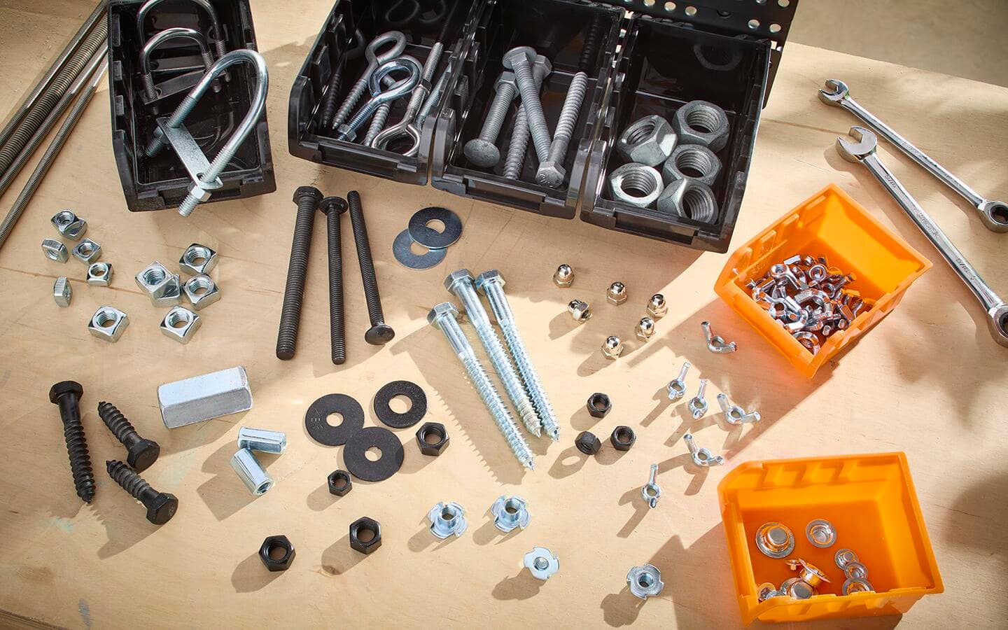 An assortment of nuts, bolts, and wrenches with plastic organizing trays.