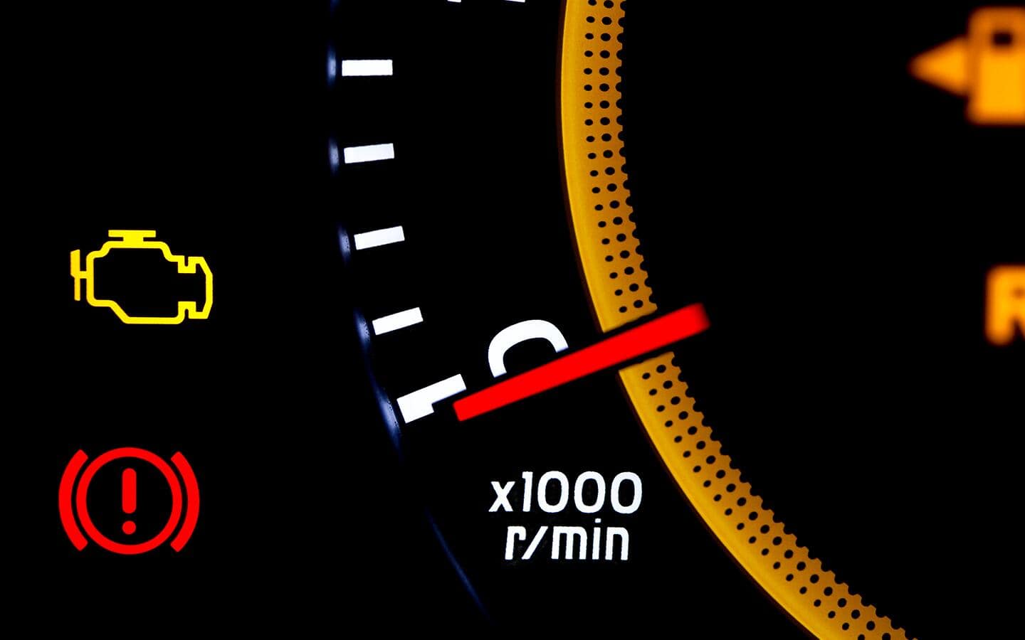 The dashboard of a car shows a check engine light.