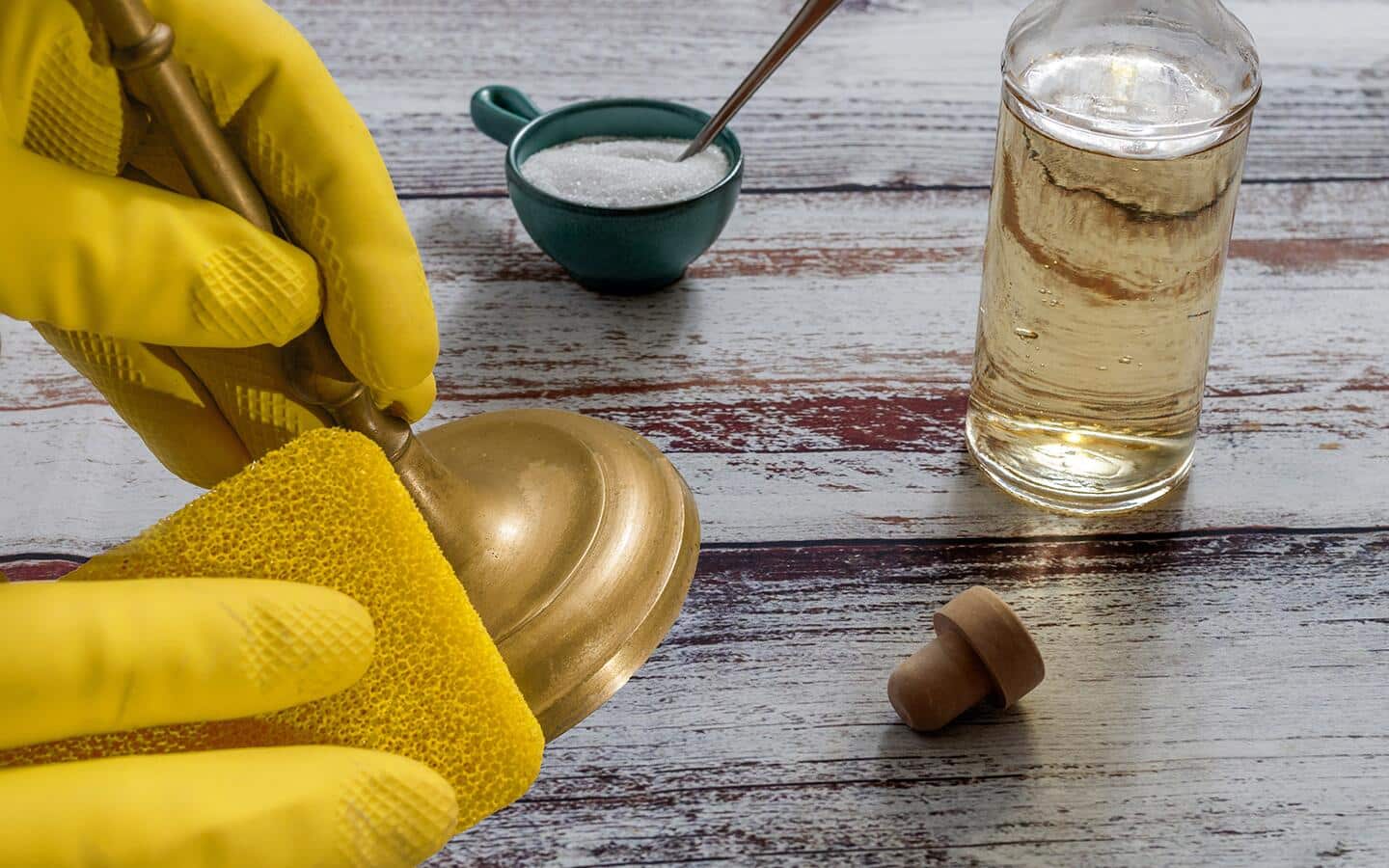 Someone cleaning brass candlesticks with vinegar and baking soda. Someone cleaning brass candlesticks with vinegar and baking soda.