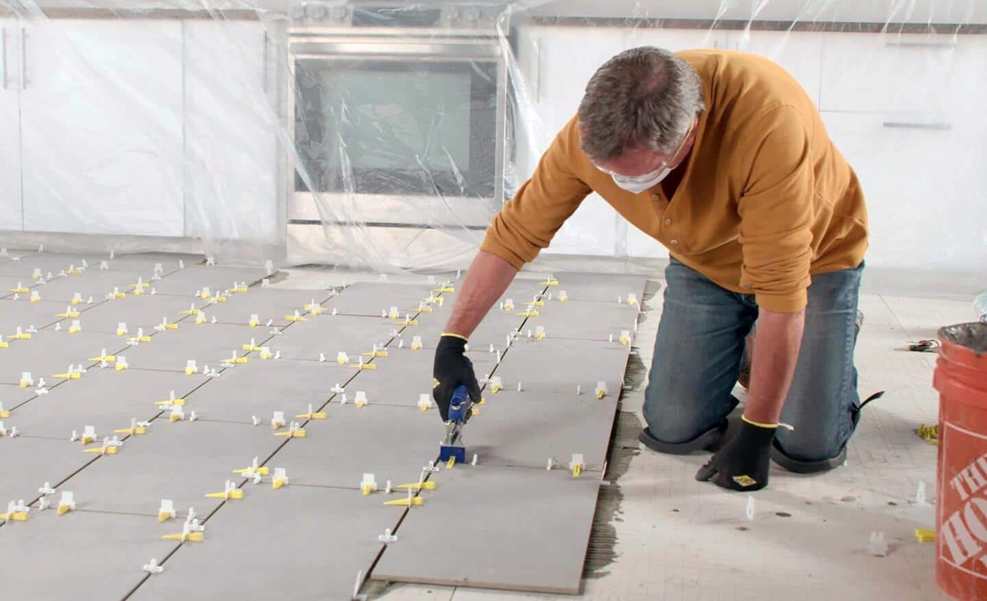 A person lays out floor tiles in sections.