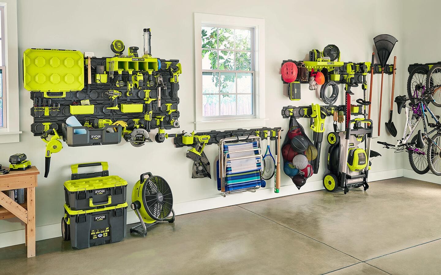 Power tools and other yard tools hang in a neatly organized garage.
