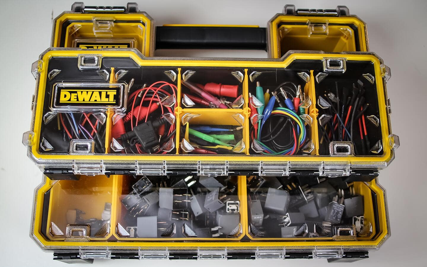 Small parts organizers from a modular storage system filled with items that an electrical technician uses, such as relays, wire nuts and test leads.