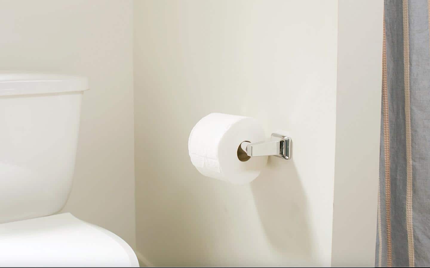 A completed toilet paper holder installation is next to a toilet.