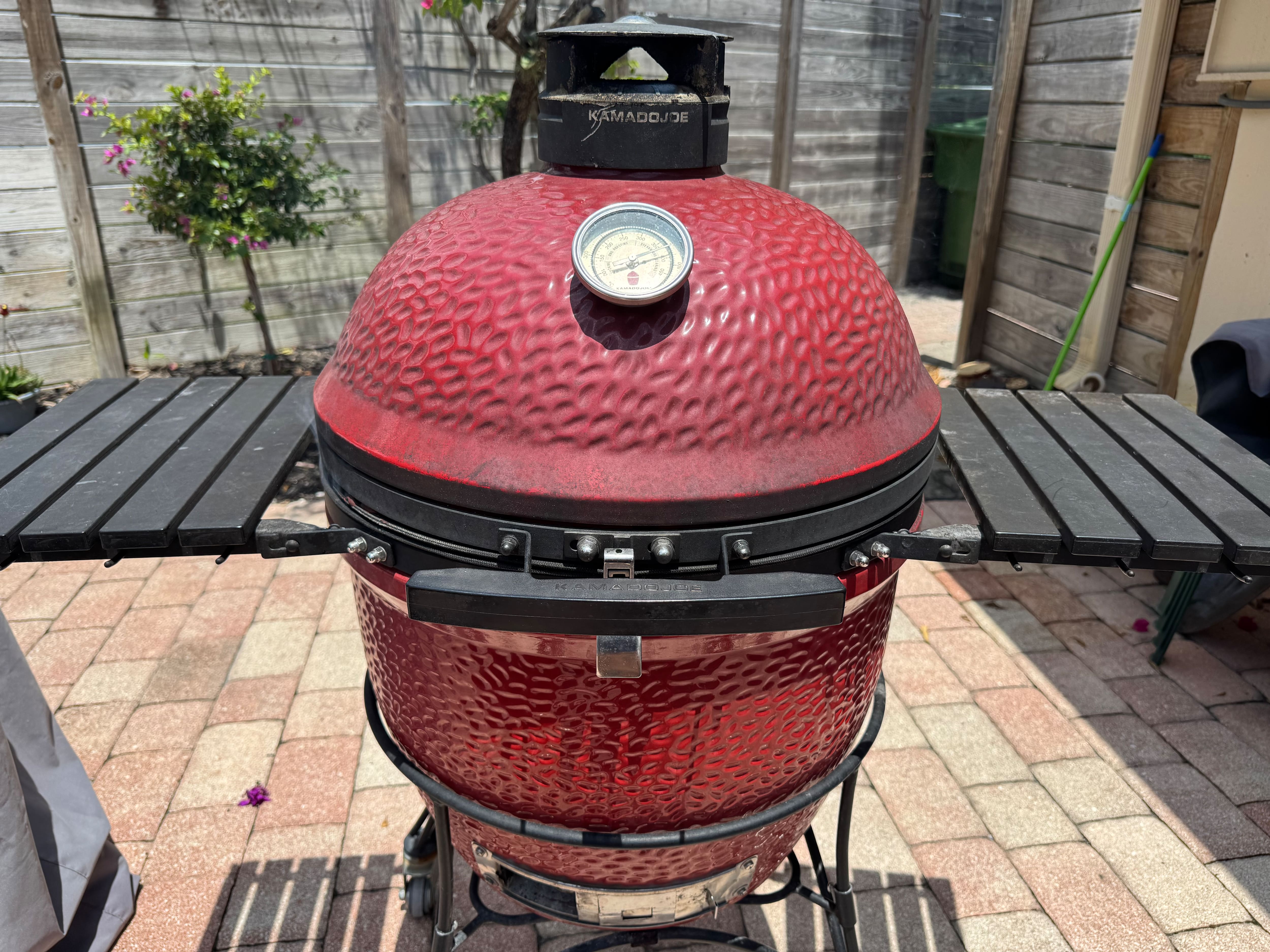 A red Kamado Joe charcoal grill. A red Kamado Joe charcoal grill.