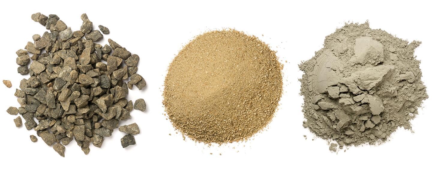 Stones, sand and cement powder piled on a table.
