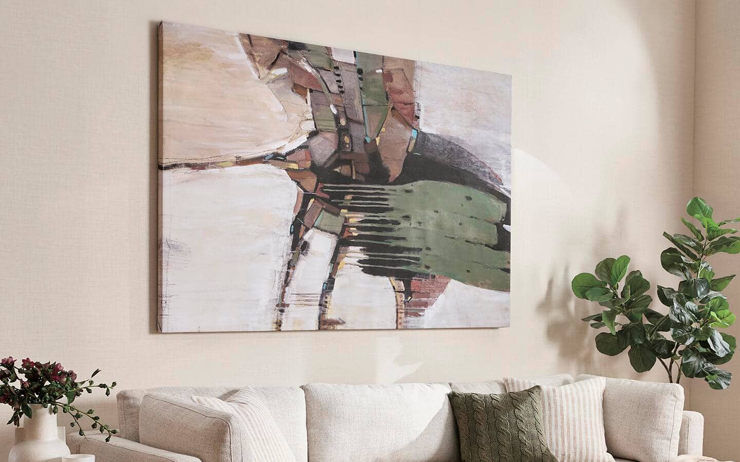 A living room with a large, colorful art piece displayed as a focal point above a creamy white sofa, anchored by plants on both ends A living room with a large, colorful art piece displayed as a focal point above a creamy white sofa, anchored by plants on both ends