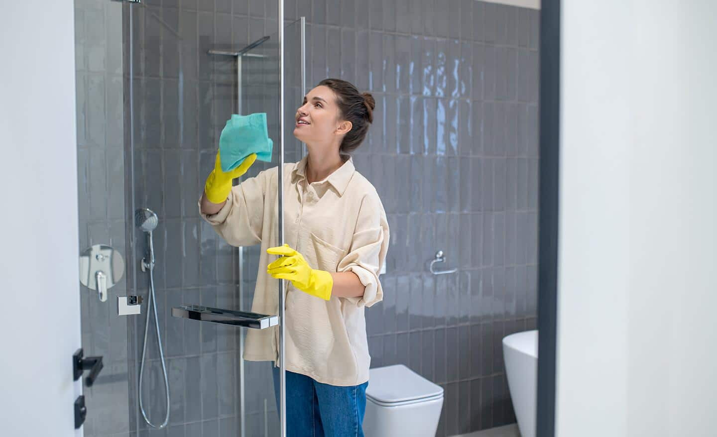 Someone cleaning a hinged shower door.