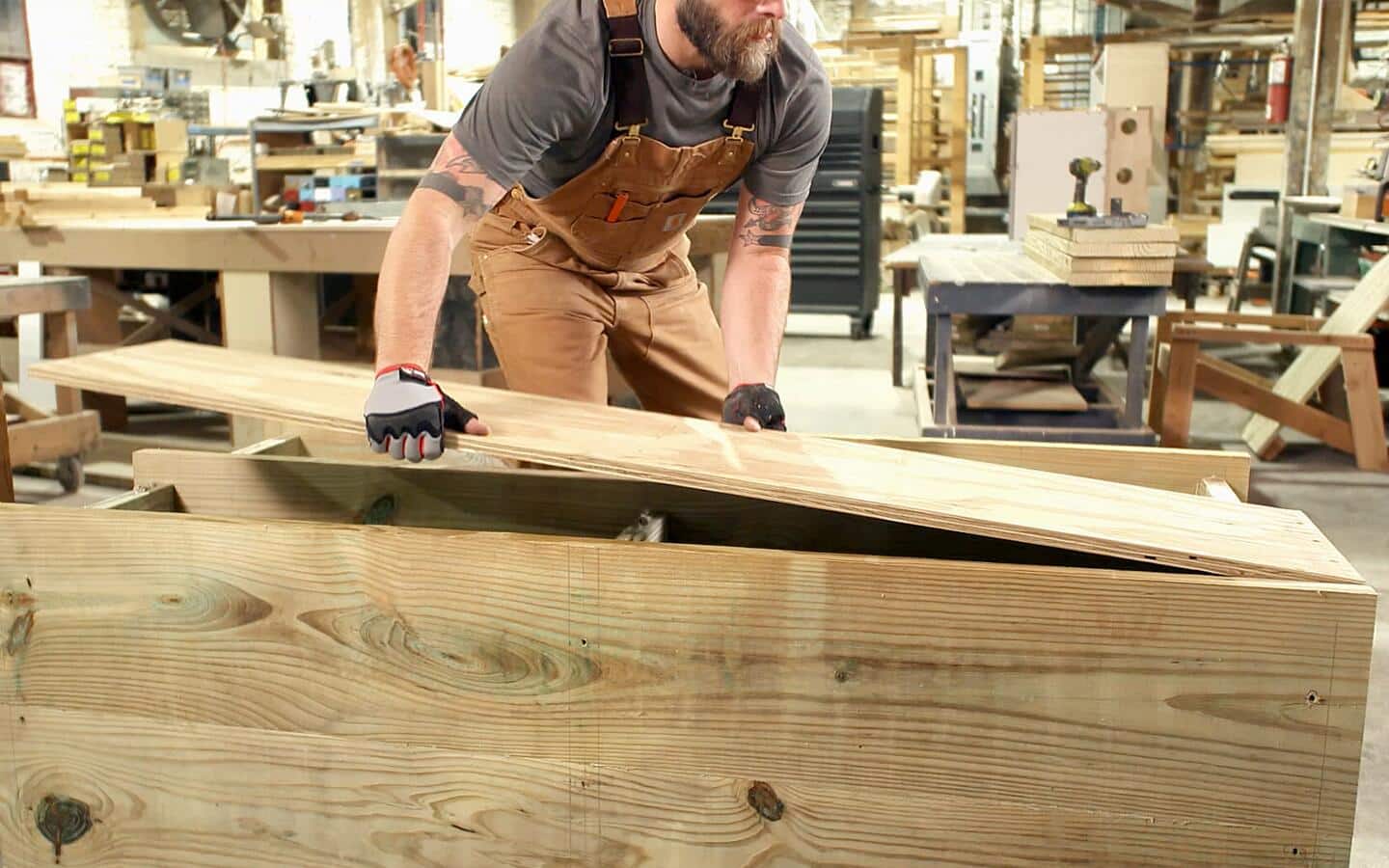 A person lays down the back panel of the outdoor grill station.
