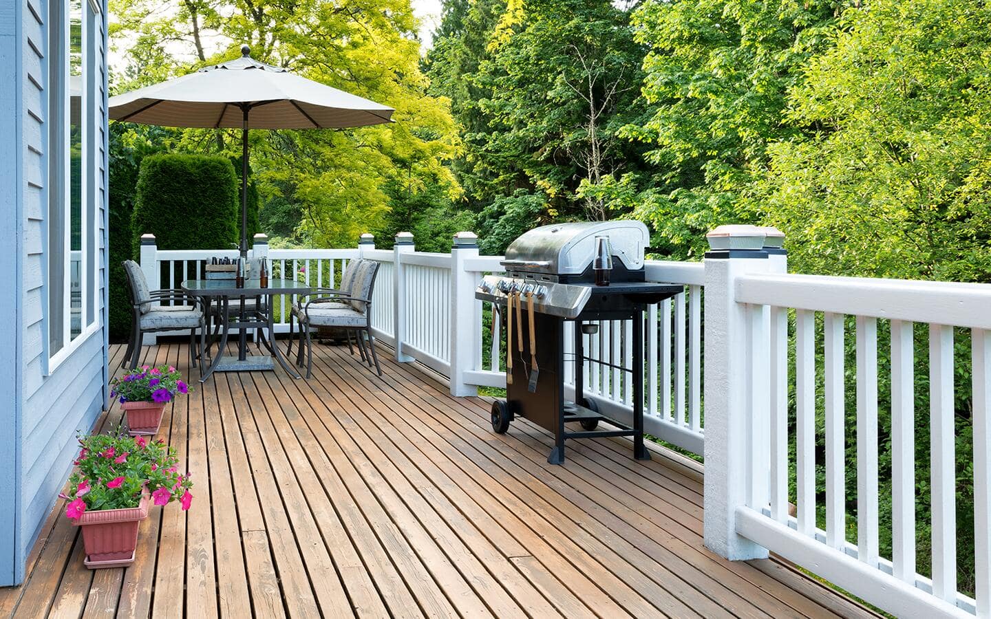 A stained deck surrounded by white railing.