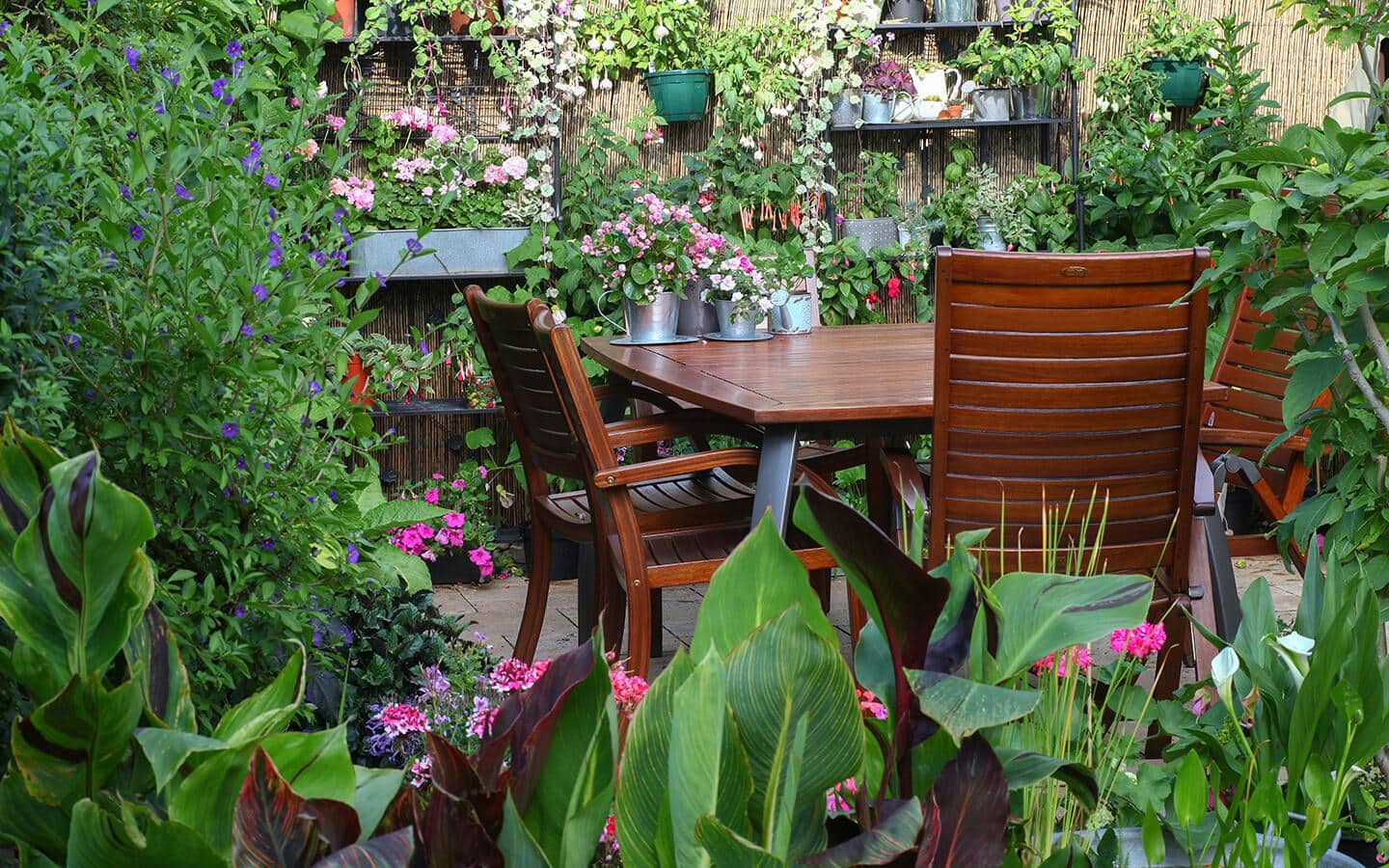 An outdoor dining table and chairs in a fall garden.