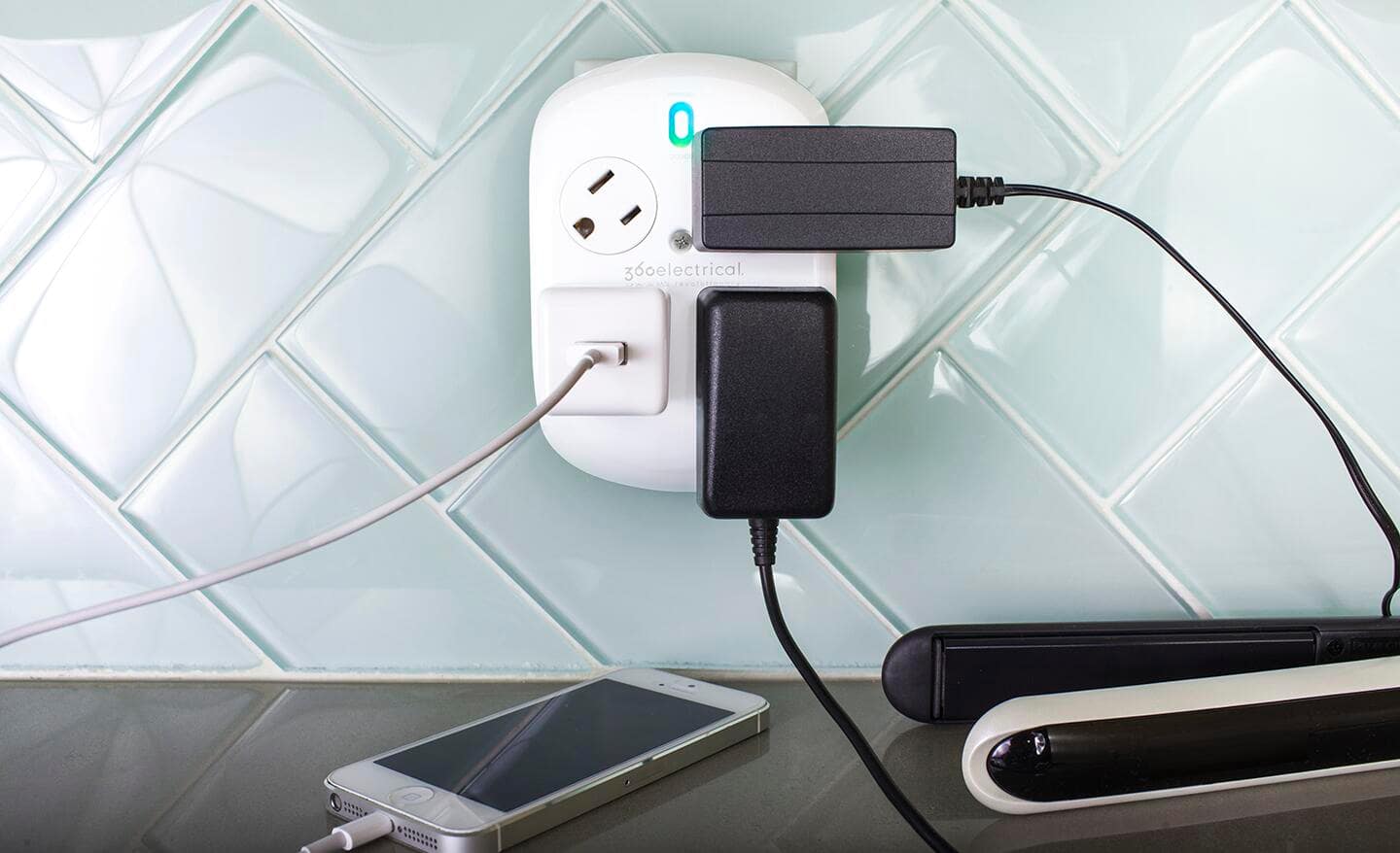 A rotating outlet installed in a tile kitchen wall.