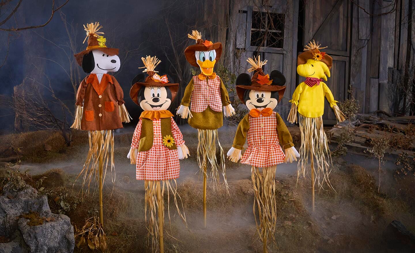 Yard decor of scarecrows with faces of Disney and Peanuts characters.