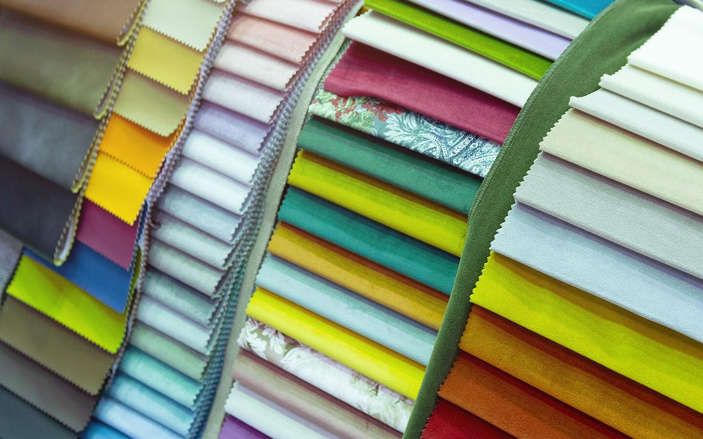A display featuring all kinds of upholstery fabrics in various colors and patterns. A display featuring all kinds of upholstery fabrics in various colors and patterns.