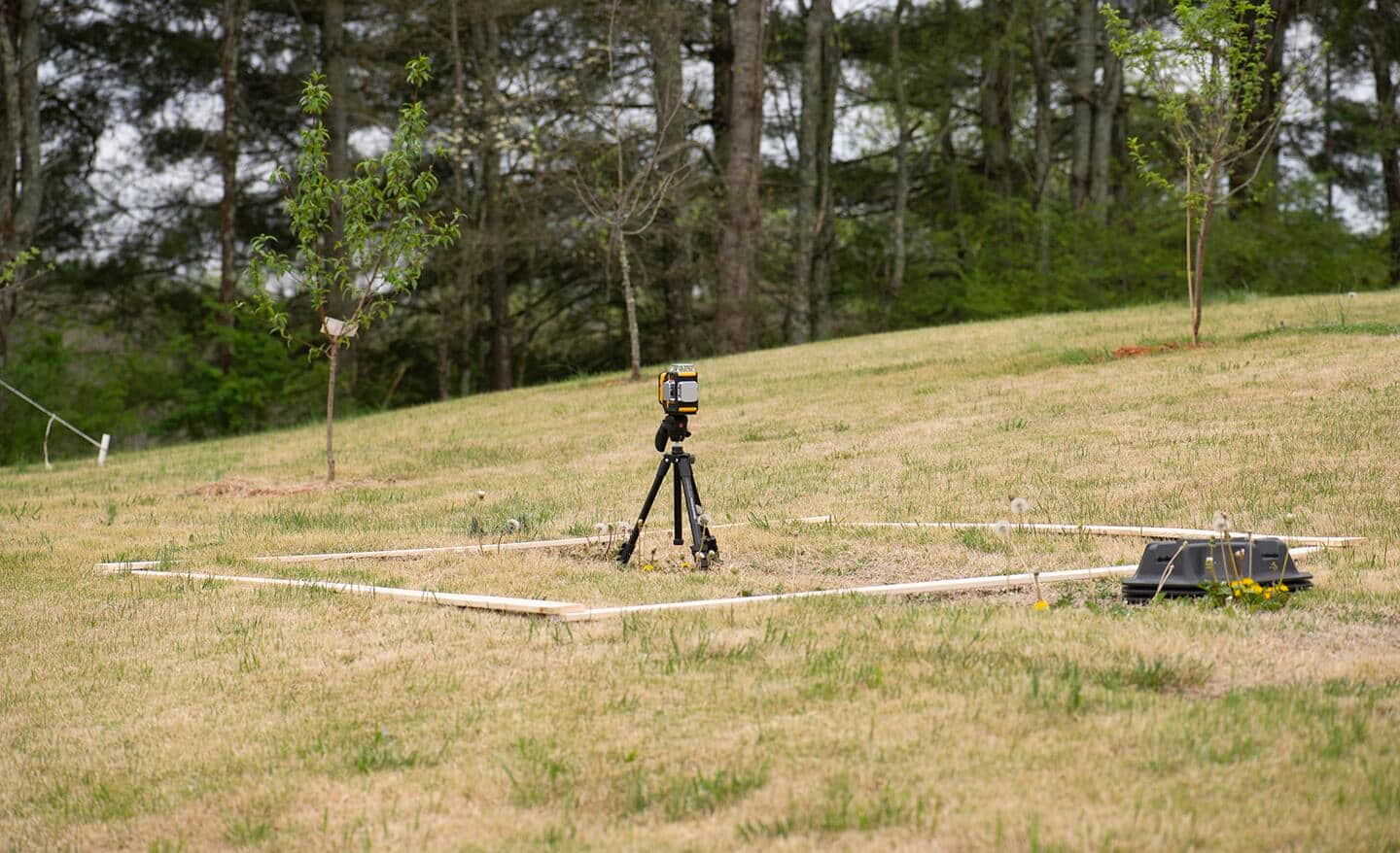 A laser level is used to find and adjust the elevation of the ground.