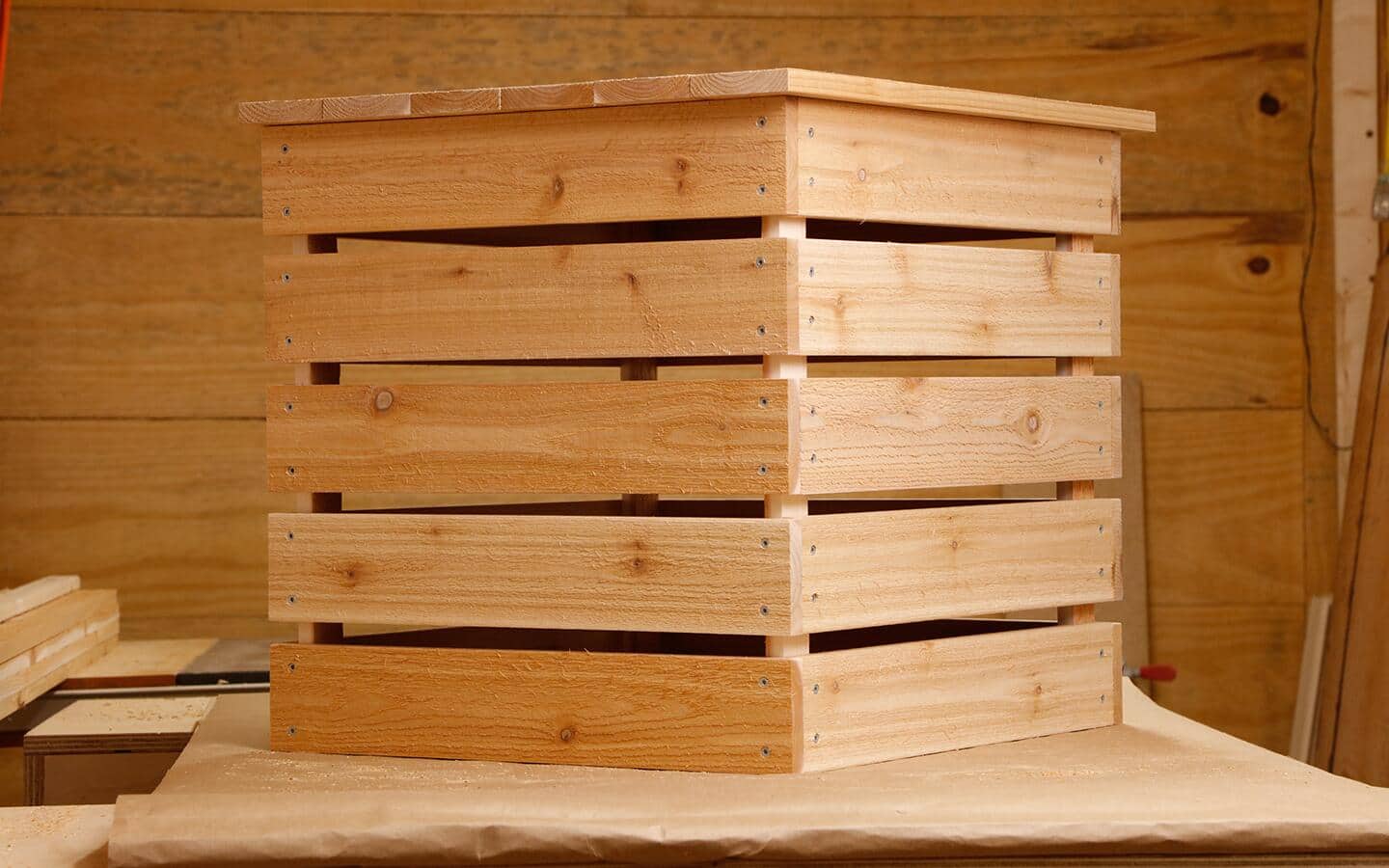 A completed DIY wooden compost bin sitting on a table.
