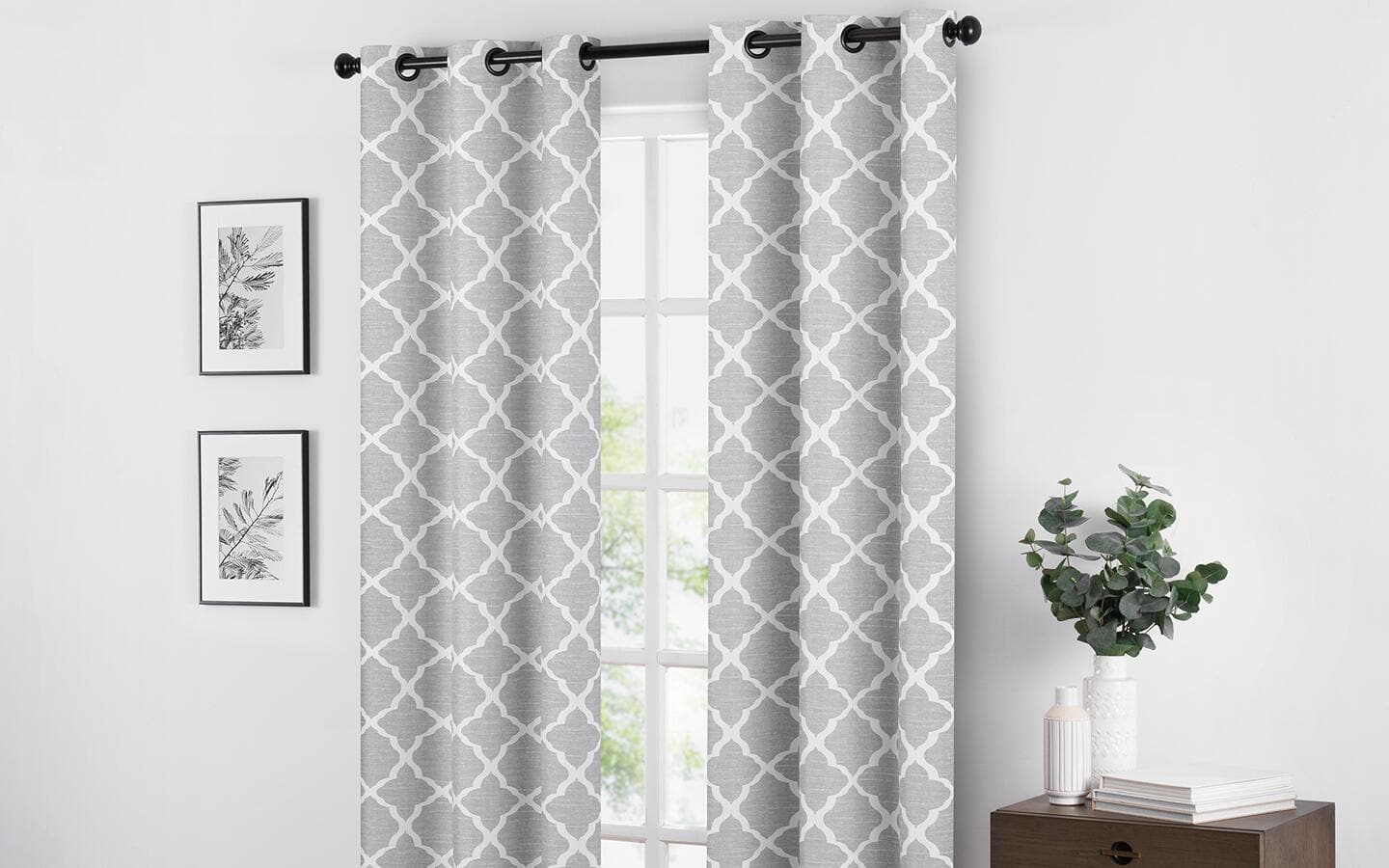 Grey- and white-patterned curtains hanging in a living room. Grey- and white-patterned curtains hanging in a living room.