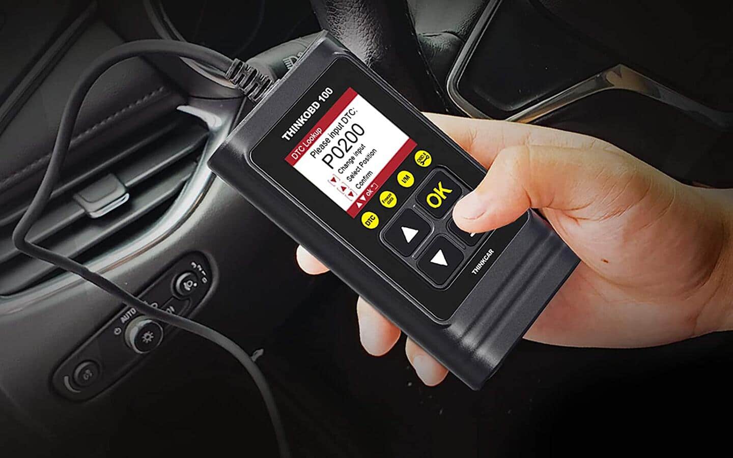 A person pressing buttons on an OBD2 scanner connected to a vehicle. A person pressing buttons on an OBD2 scanner connected to a vehicle.