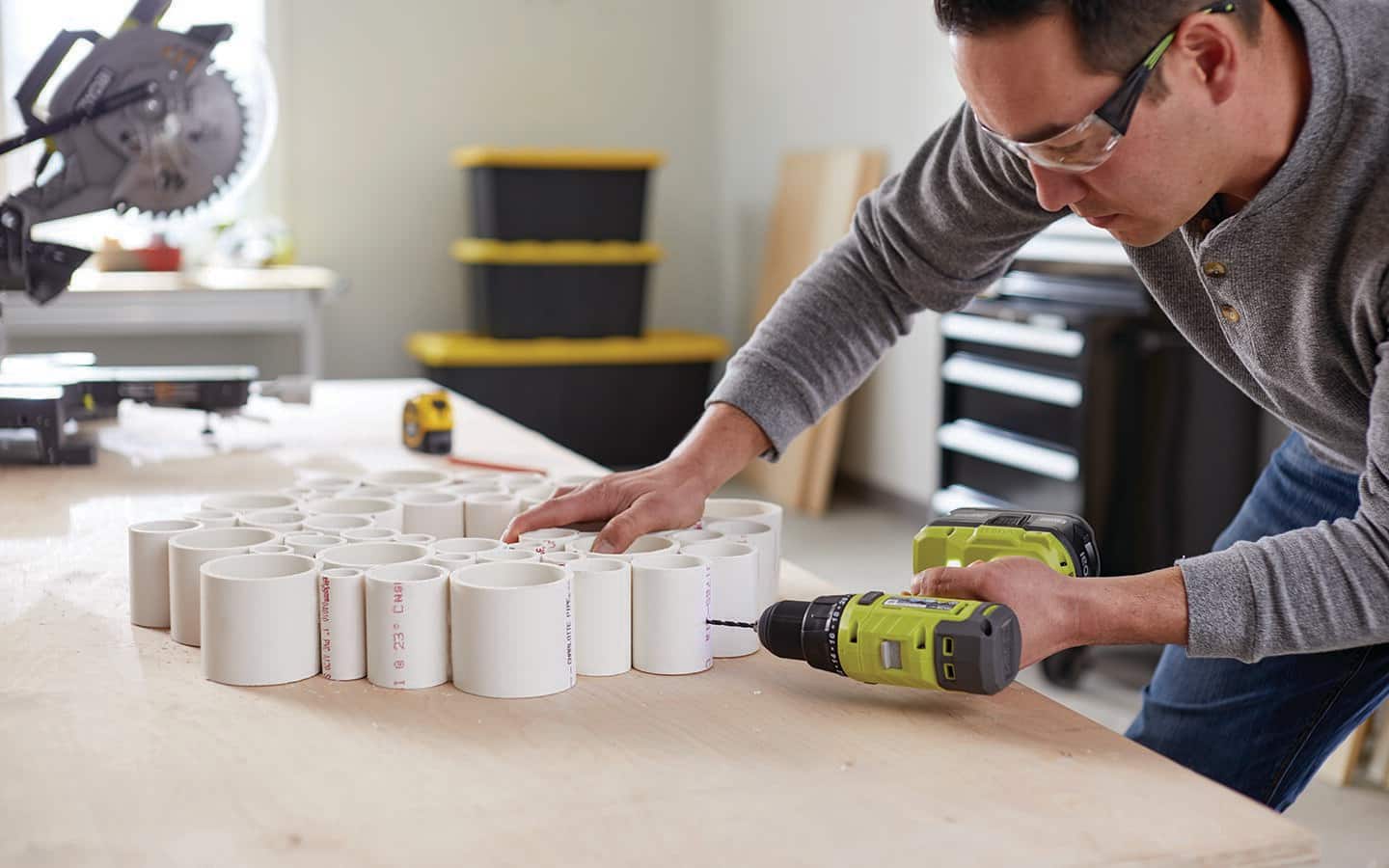 A man screwing sections of a PVC holiday wreath together. A man screwing sections of a PVC holiday wreath together.