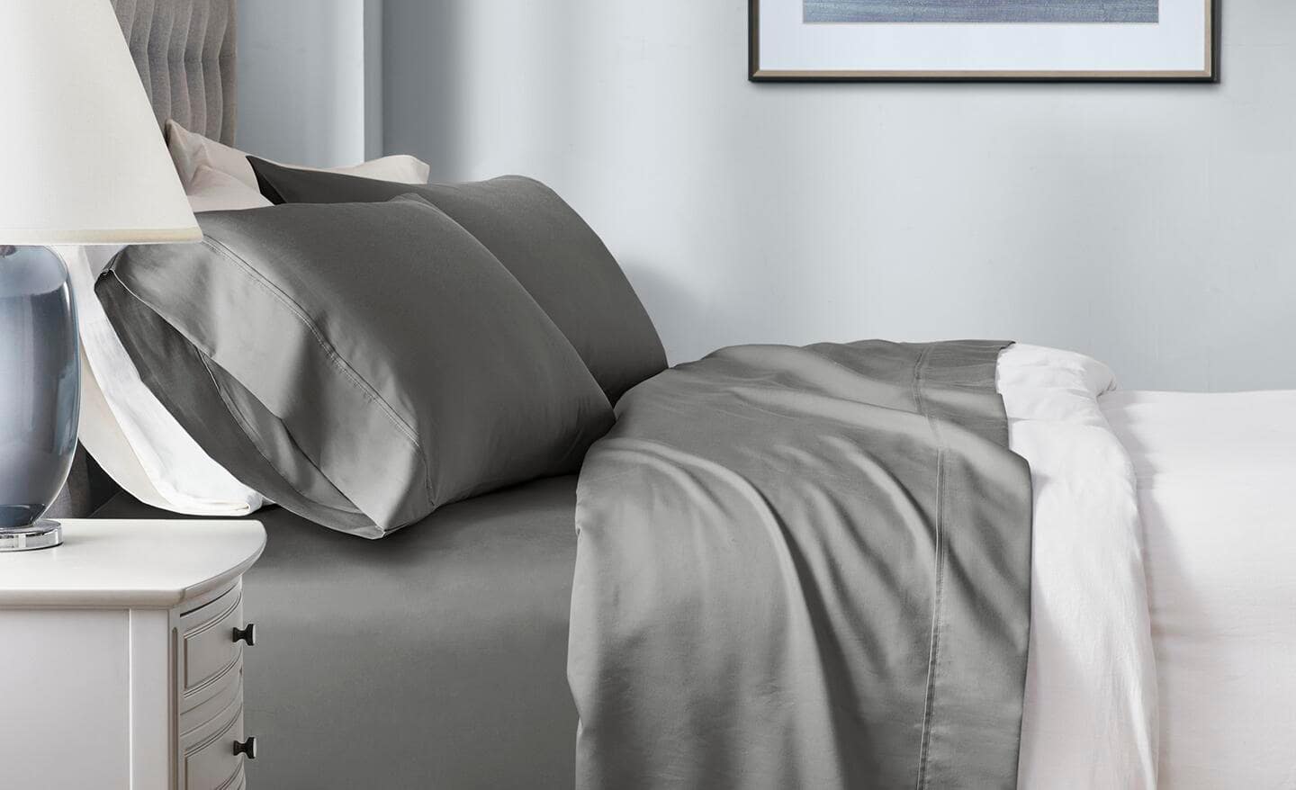 A bed made with beige and white linen.