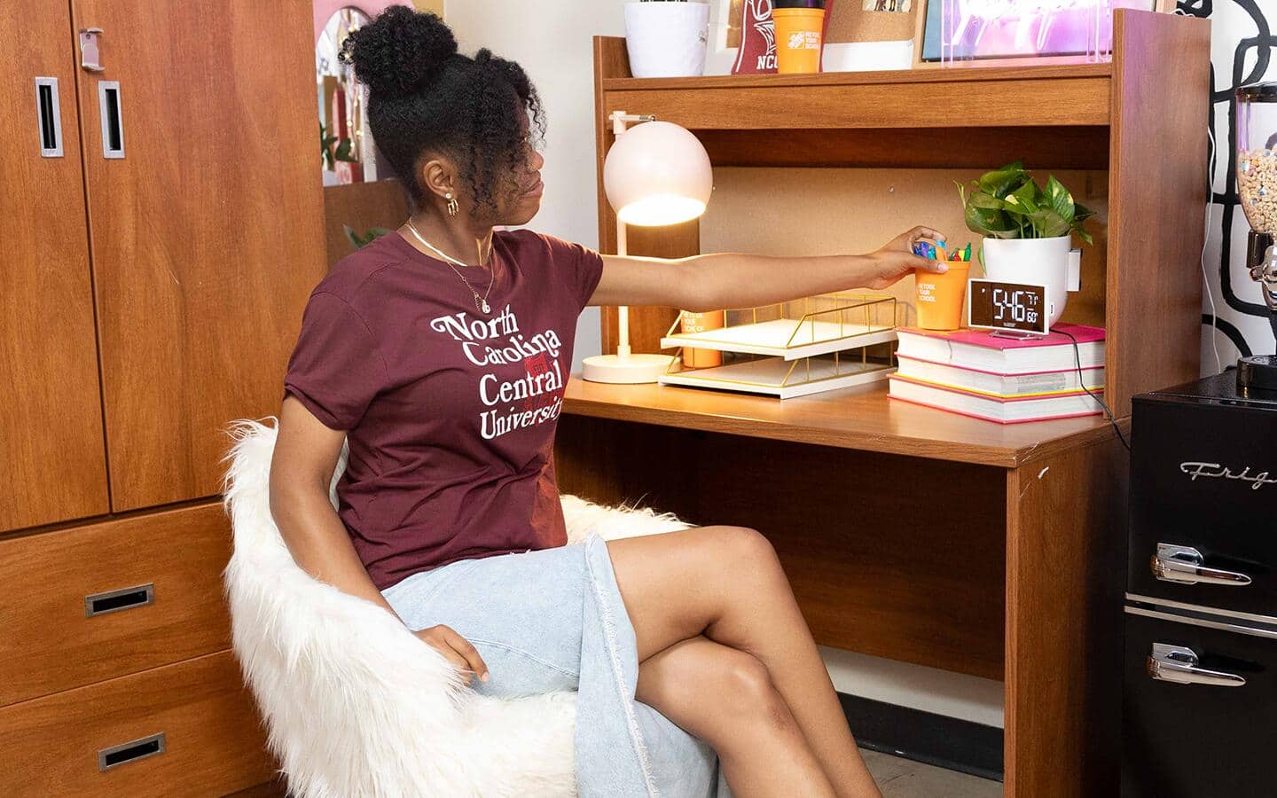 College student sitting at desk in a faux fur covered chair. College student sitting at desk in a faux fur covered chair.
