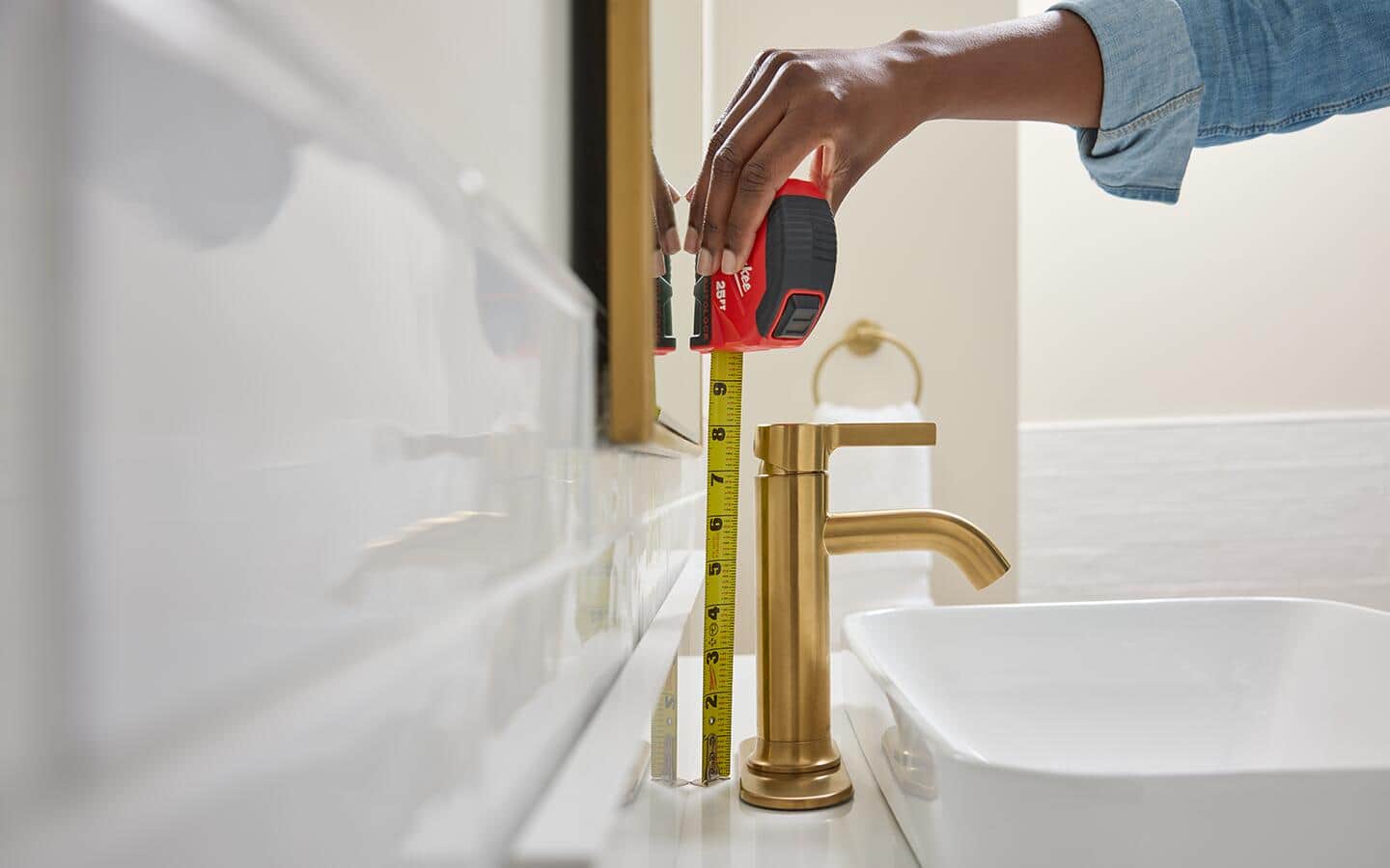 A tape measure is used to find the heights of a single hole faucet with base plate.