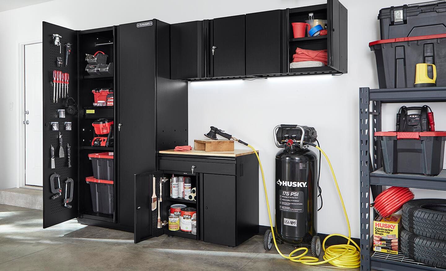 Black cabinets in a garage hold tools and supplies