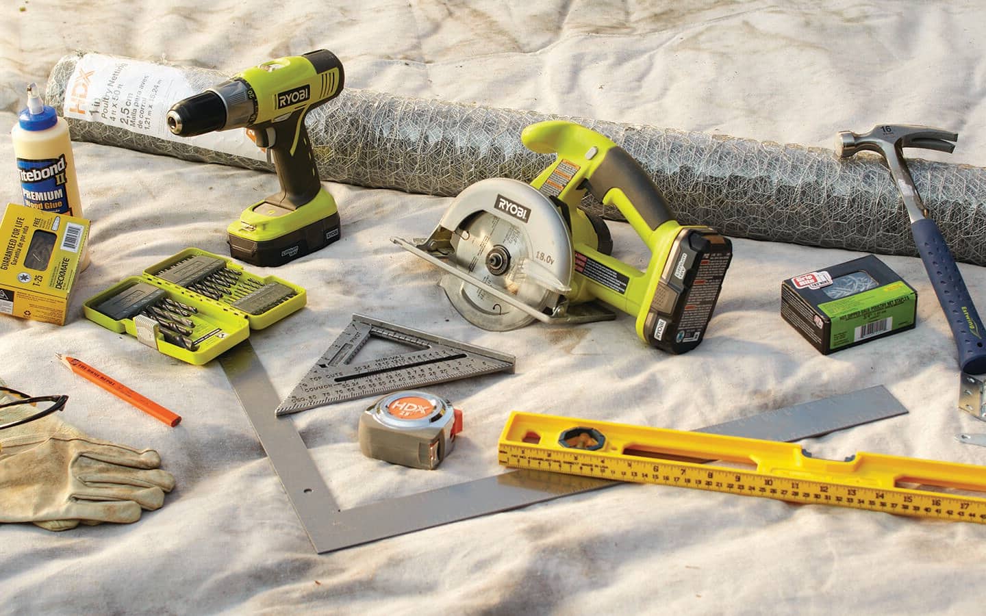 A cordless drill and other tools and materials needed to build a garden enclosure. A cordless drill and other tools and materials needed to build a garden enclosure.