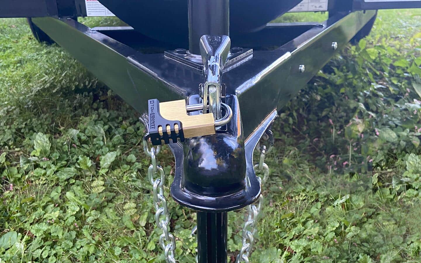A gold hitch lock protecting a blue ball mount and hitch.