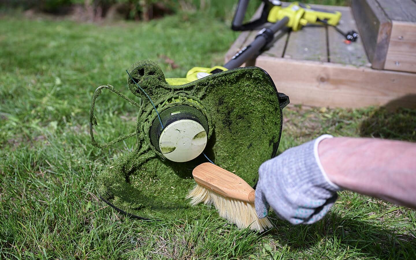 A dirty string trimmer filled with grass clippings.