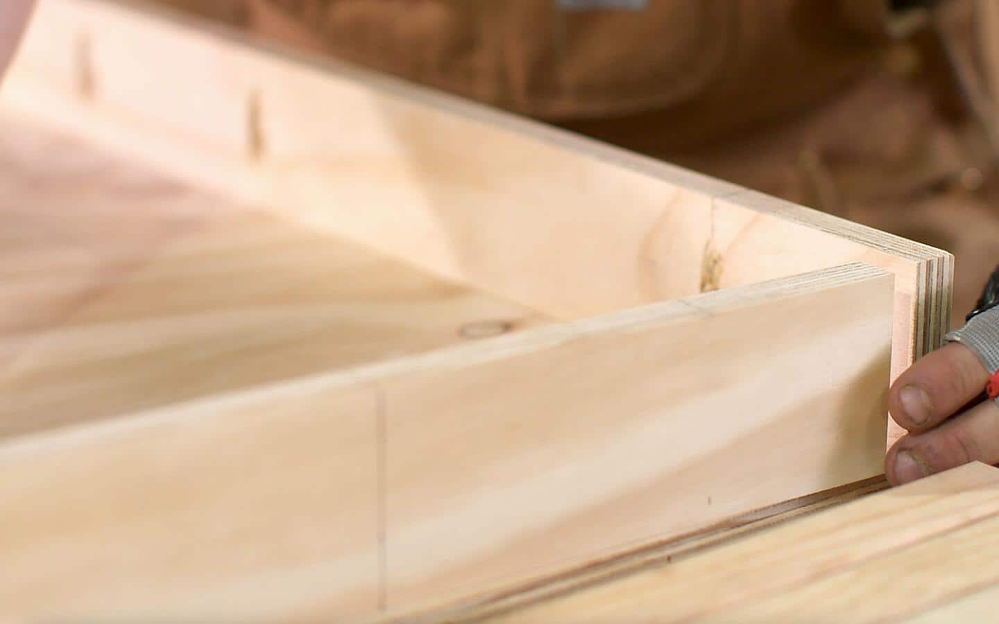 Someone assembling side wood pieces of the top of the DIY desk.