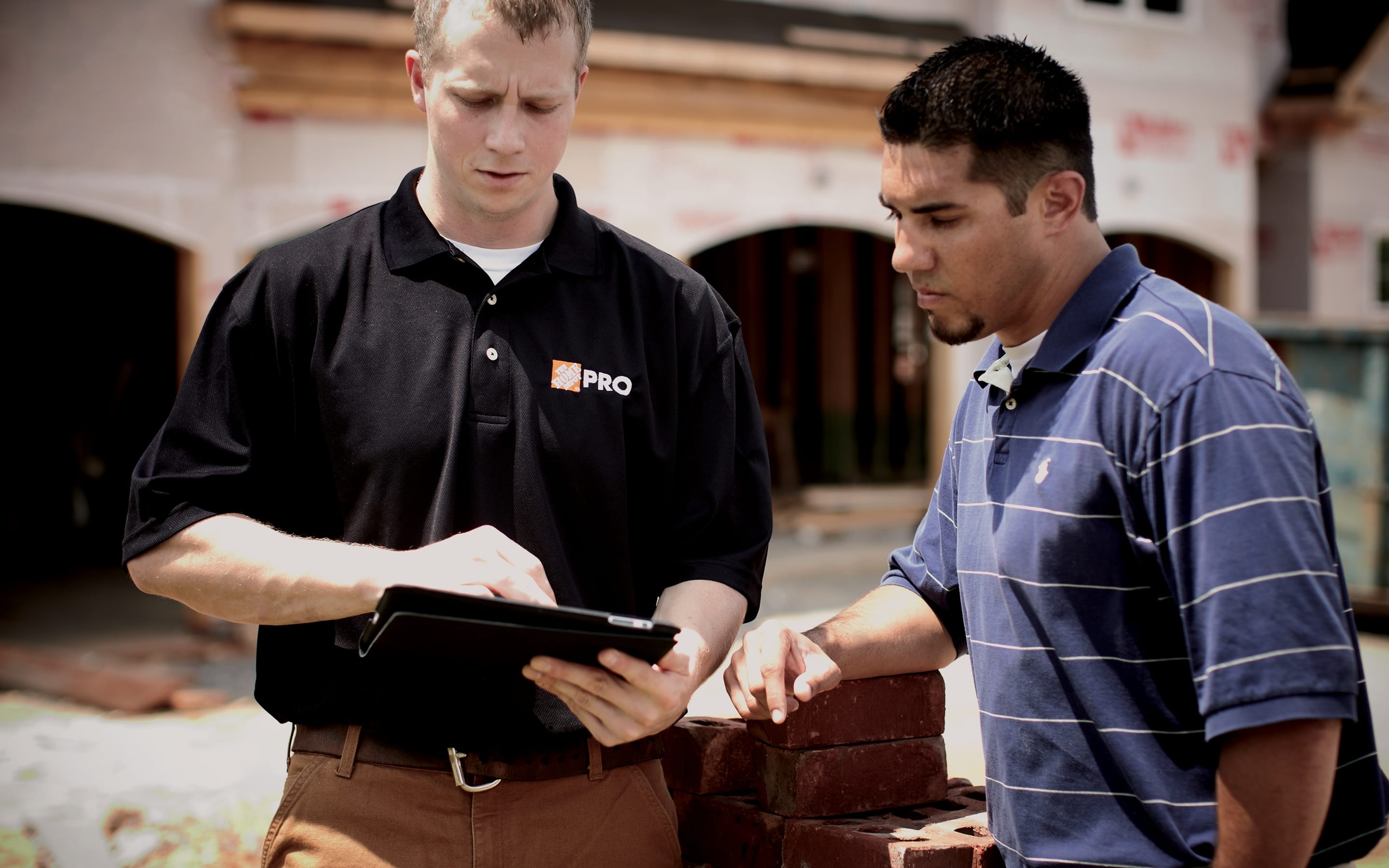 A Pro showing a team member a tablet. A Pro showing a team member a tablet.